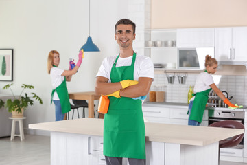 Canvas Print - Team of professional janitors in uniform cleaning kitchen