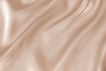 the texture of the satin fabric of beige color for the background