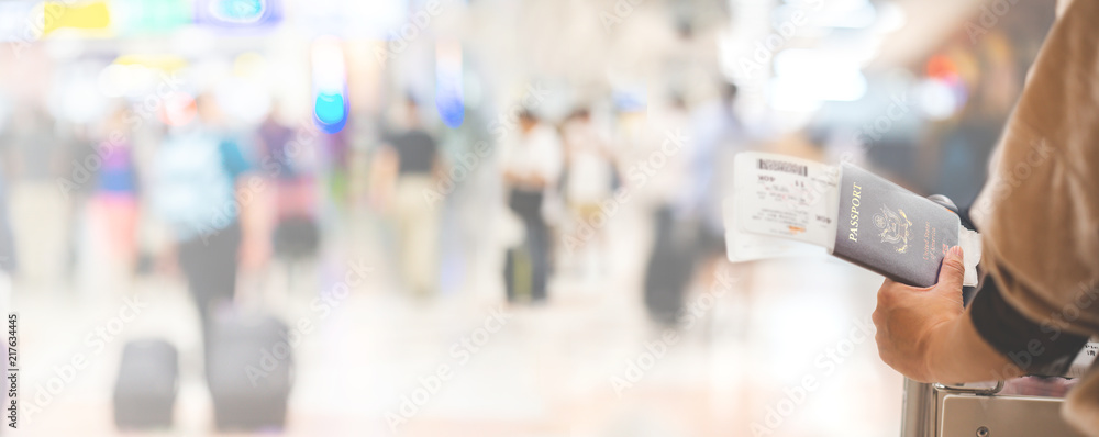 Closeup of girl holding passports and boarding pass at airport , panorama - obrazy, fototapety, plakaty 