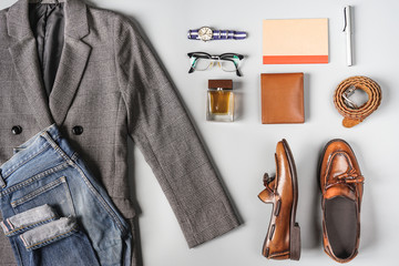 Top view set of classic clothes, plaid blazer, brown tassel loafer and accessories on grey background