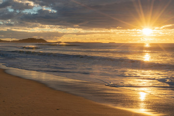 Sunrise over the ocean with star burst around sun