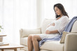 © Blue Jean Images - Cheerful pregnant woman relaxing at home