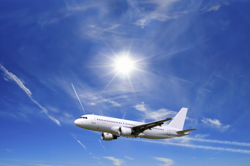 Airplane flying over sunny blue sky and Alpine mountains background