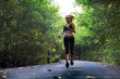 © TheVisualsYouNeed - lifestyle outdoors portrait of young attractive and fit woman with hairband training hard on asphalt road running workout at beautiful trees city park