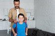 © LIGHTFIELD STUDIOS - portrait of father helping son to wear backpack at home, back to school concept