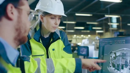Fototapete - At the Factory: Male Mechanical Engineer and Female Chief Engineer Work Together on the Personal Computer, They  Discuss Details of the 3D Engine Model Design.