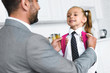 © LIGHTFIELD STUDIOS - father in suit and little daughter in school uniform with backpack in kitchen at home, back to school concept