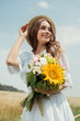 © LIGHTFIELD STUDIOS - portrait of smiling woman in white dress with bouquet of wild flowers in field