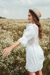 © LIGHTFIELD STUDIOS - pretty woman in straw hat and white dress on meadow with wild flowers