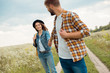 © LIGHTFIELD STUDIOS - happy lovers holding hands in field with wild flowers