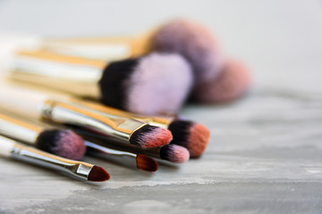 Set of makeup brushes on grey background