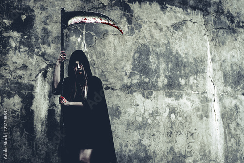 Cuadros en Lienzo Demon witch with reaper standing in front of grunge wall background