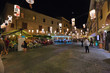 Night view of the historic center with the bustling city life of the city of Alghero in Sardinia, Italy.