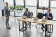 © LIGHTFIELD STUDIOS - high angle view of young businessmen using laptops and playing with soccer and basketball balls in office
