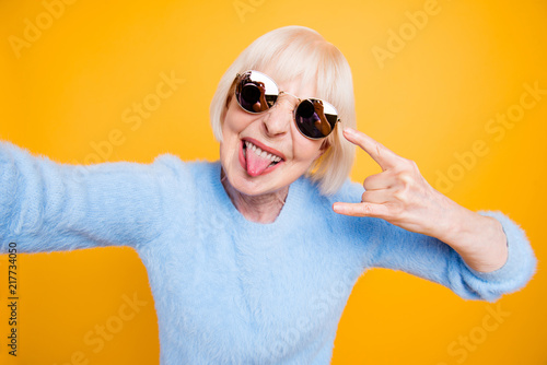 Fotomural Modern old lady take selfie picture showing sign rock and roll i