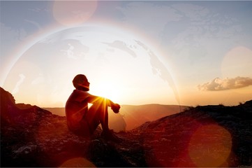 young man pray outdoor on top