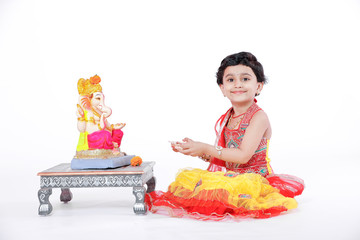 Little Indian girl child with lord ganesha and praying , Indian ganesh festival