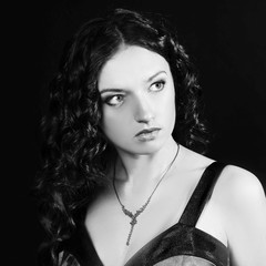 closeup of beautiful young woman in evening black dress.isolated on black background black and white photo