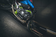 Low Angle View Of Male Biker Riding Motorbike At Road Parking Garage