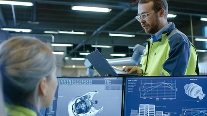 Aufkleber - At the Factory: Male and Female Mechanical Engineers Use Laptop and Personal Computer while Discussing Robotic Arm Manufacturing Project. Screen Shows 3D Engine Concept made with CAD Software.