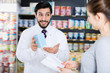 © JackF - Male specialist is helping female client choose medicine in pharmacy.