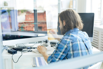 Wall Mural - young programmer testing new software or decoding data in front of computer screen