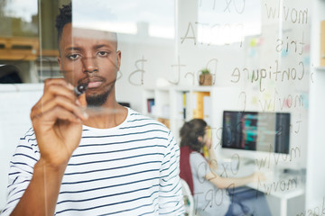 Wall Mural - serious guy with highlighter writing down software codes on board while working in office