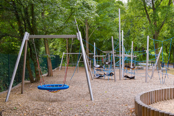 Climbing frame with equipment out of ropes, metal poles and other elements on a public playground in Berlin.