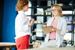 © pressmaster - Confident teacher in smart casual making notes in notepad while listening to her trainee point of view about course of artwork