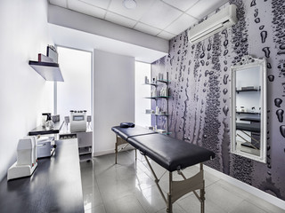 View of an Interior of a modern clean massage room with black and white luxury decor.