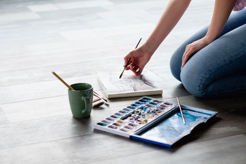 Poster - art painting hobby. creative leisure. girl drawing a picture sitting on the floor. talent inspiration creation and self expression concept