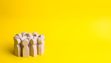 Group Of Wooden People Figurines On A Yellow Background. Crowd, Meeting, Social Activity. Society, Social Group. Herd Instinct, Management Of People. Human Resources, Workers Stand Together.