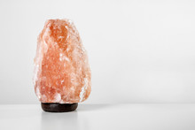 Himalayan Salt Lamp On Table Against Light Background