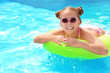 © New Africa - Little girl with inflatable ring in swimming pool