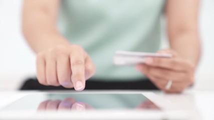 Wall Mural - Young woman making online payment on digital tablet with credit card