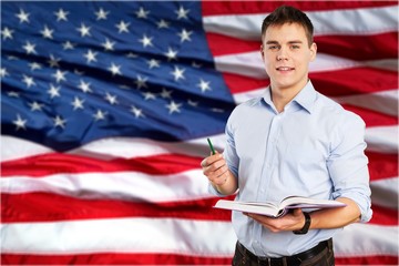 Canvas Print - Young male teacher   standing with book