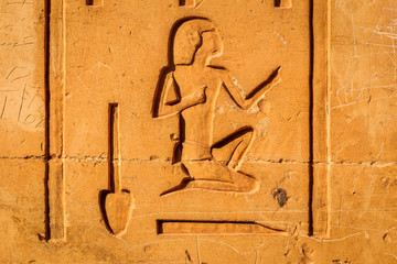 Wall Mural - stone wall with Egyptian carving figures and hieroglyphs, Aswan, Egypt, Africa.