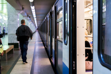 Wall Mural - subway train staying on a metro station with doors open with defocused background