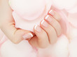 © looking2thesky - Closeup image of beautiful woman's hands with light pink french manicure on the nails. Skin care for hands, manicure and beauty treatment. Elegant and graceful hands with slender graceful fingers