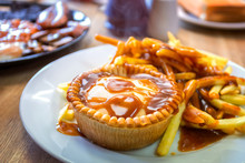 A Plate Of Mince Beef Pie Served With Potato Chips In Traditional English Meal