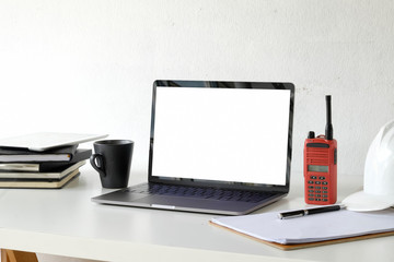 Engineer workspace with laptop and safety helmet.