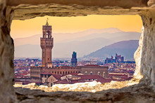 Ancient Florence cityscape and Palazzo Vecchio sunset view through stone window