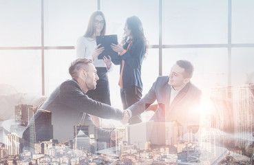 Young team of coworkers making great business discussion in modern coworking office. Teamwork people concept. Double exposition, panorama of modern city