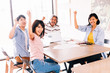 © twinsterphoto - Casual and happy smiling Asian business casual people celebrating success and hands up having fun meeting together.