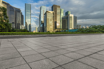 empty pavement and modern buildings against blue sky