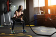 © Screaghin - Athletic young woman doing crossfit exercises with a rope.