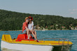 © Newman Studio - Shot of happy couple sitting on pedal boat. Young man and woman in love enjoying boating in the lake.