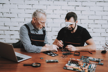 Wall Mural - Two Men Repairing Mobile Phone in Modern Workshop.