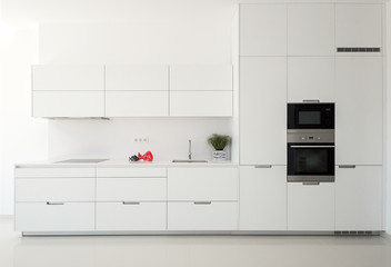  White empty classic kitchen in front view. Kitchen appliances.