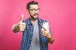 © denis_vermenko - Portrait of a cheerful bearded man taking selfie and showing thumbs up gesture over pink background. Isolated.